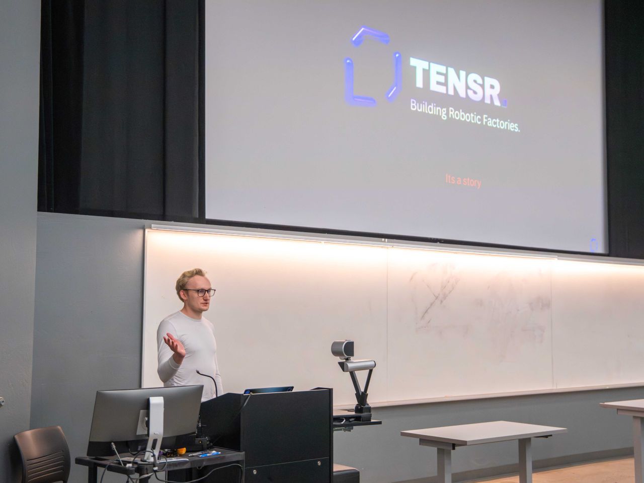 Eric Berndt at the podium with the Tensr title slide: Building Robotic Factories